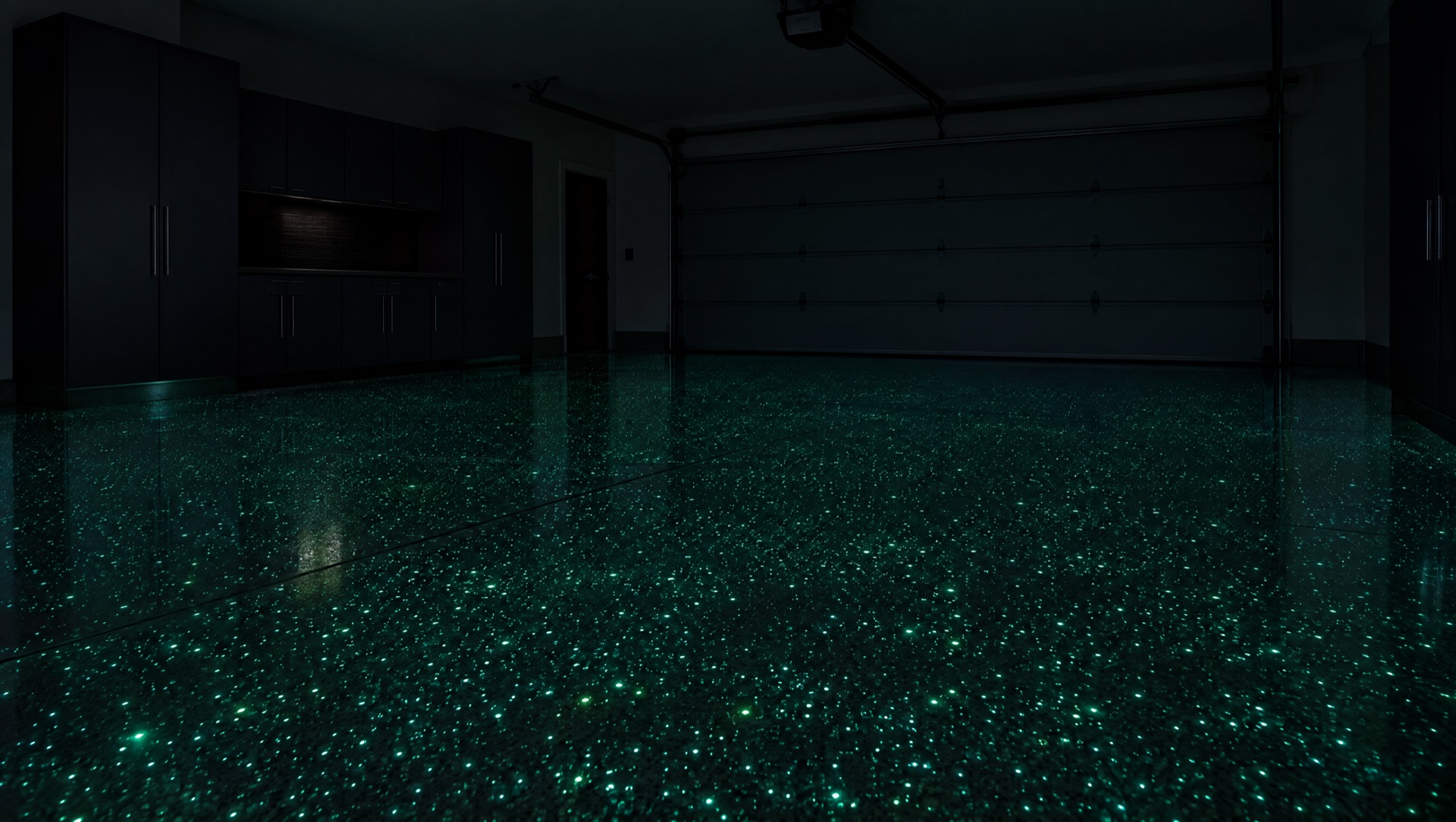 A dark garage whose epoxy floor glows with soft aqua-green specks after the lights are turned off